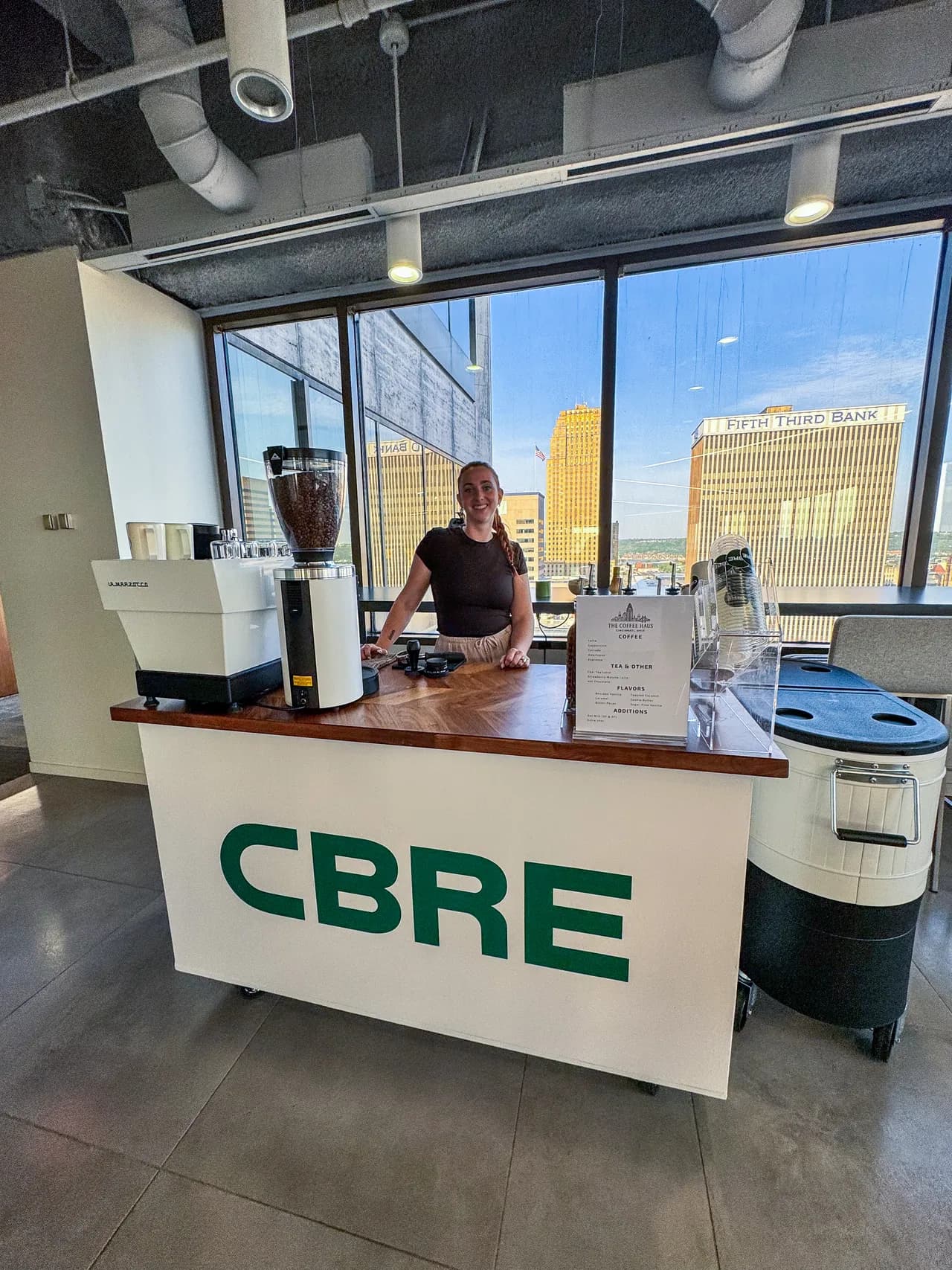 Branded corporate coffee cart set up in a CBRE office overlooking the Cincinnati skyline
