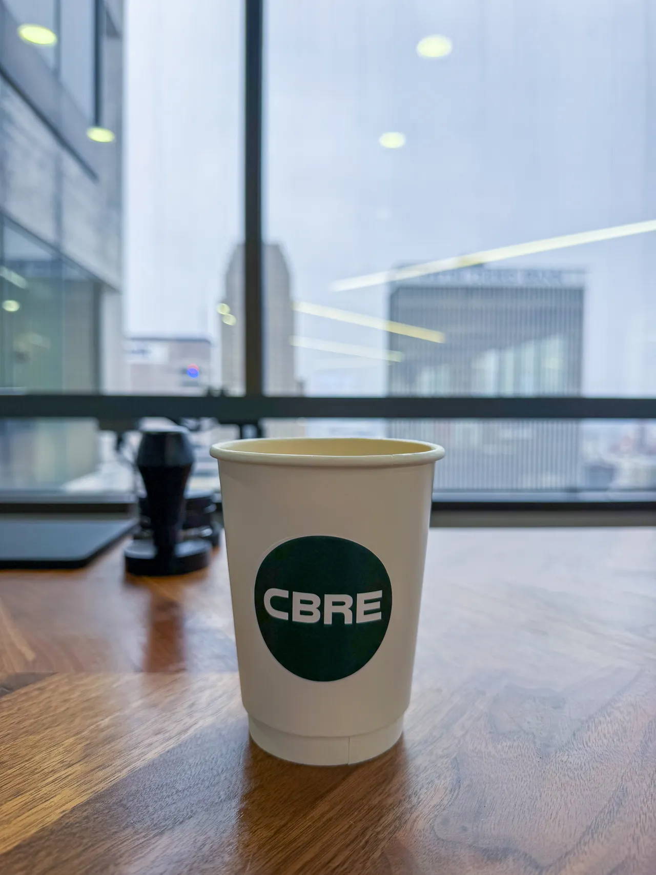 Custom CBRE-branded coffee cup served at a corporate coffee catering event