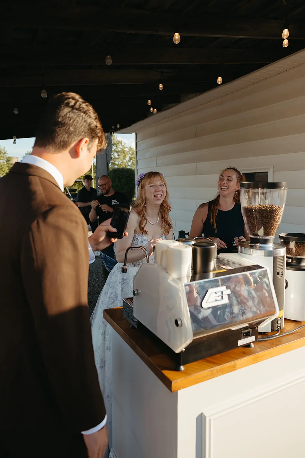 Wedding guests ordering handcrafted espresso drinks from The Coffee Haus cart